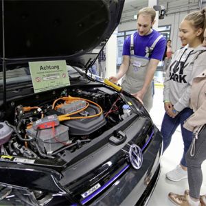Kraftfahrzeug-Mechatroniker fr System- und Hochvolttechnik zeigt Gsten an einem e-Golf, worauf bei Arbeiten an Elektro-Fahrzeugen zu achten ist.